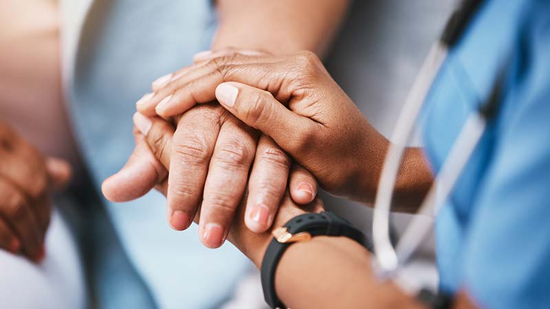 Caregiver holding patient's hand